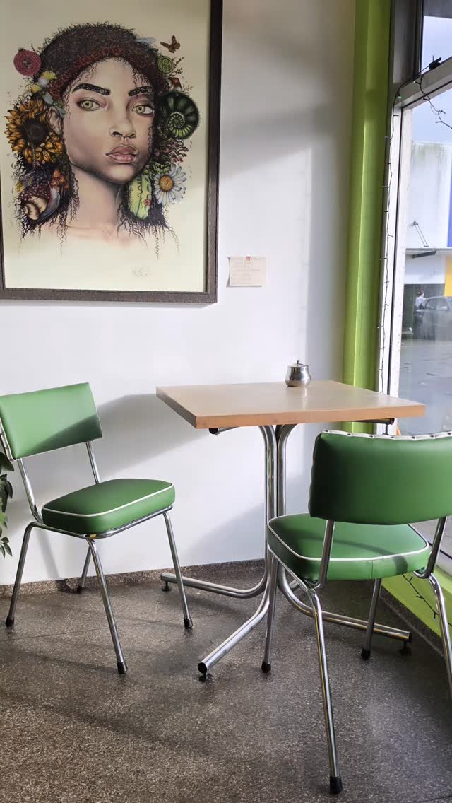 Green vinyl chairs at a small table beside a window with lime green trim