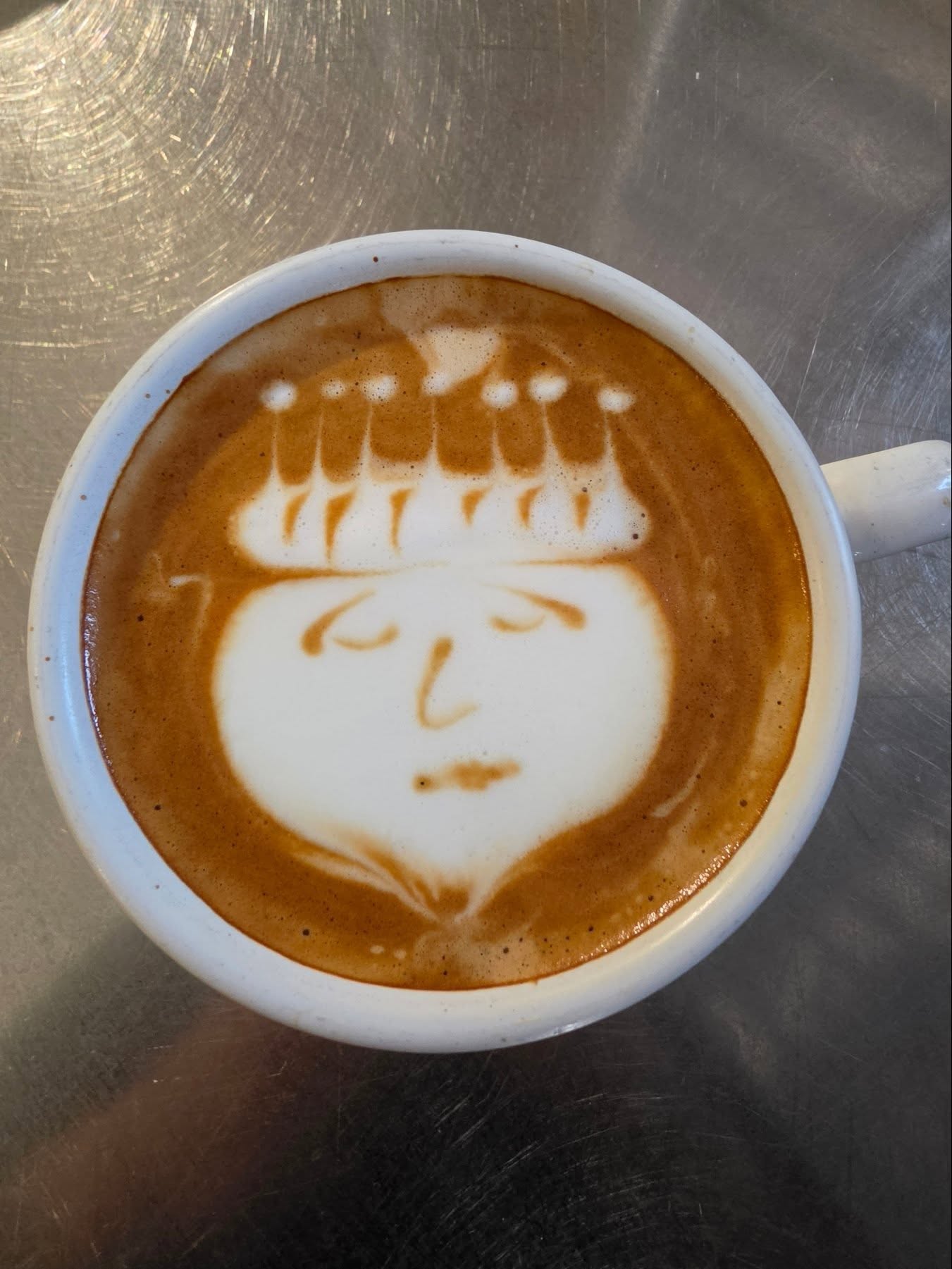 Latte art of a smiling face in a white cup