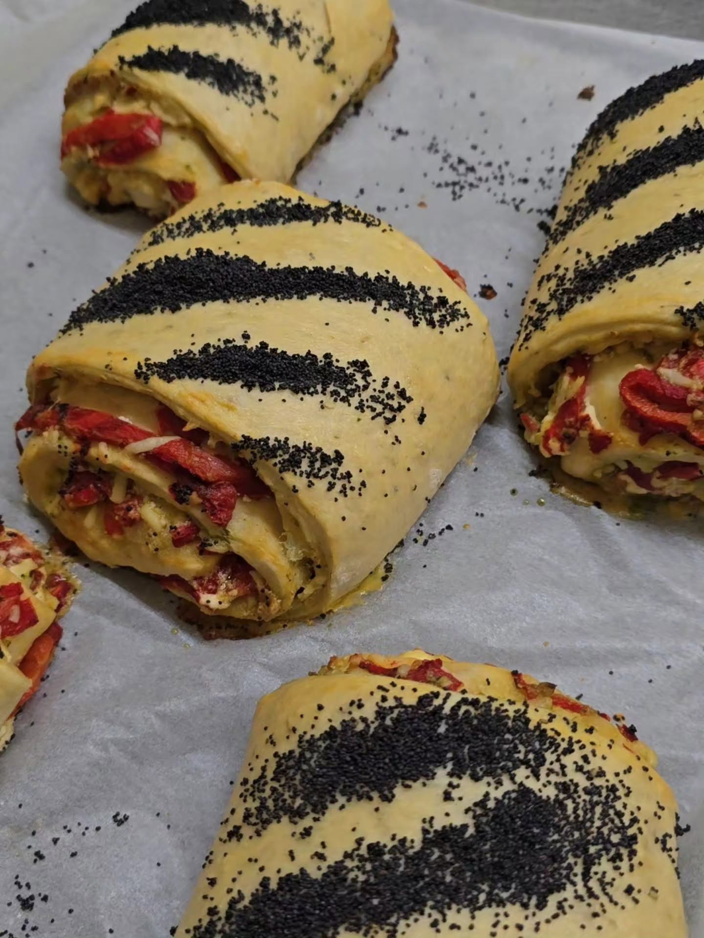 Savoury scrolls topped with poppy seeds, fresh from the oven